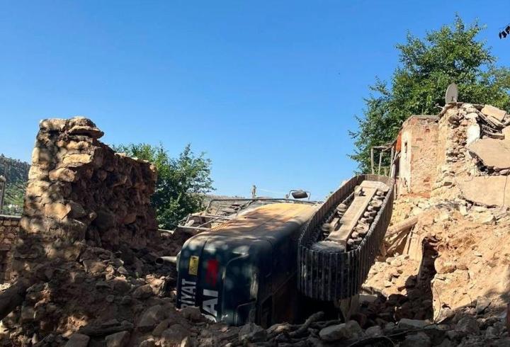 Gercüş’te, metruk evin yıkımı sırasında iş makinesi devrildi